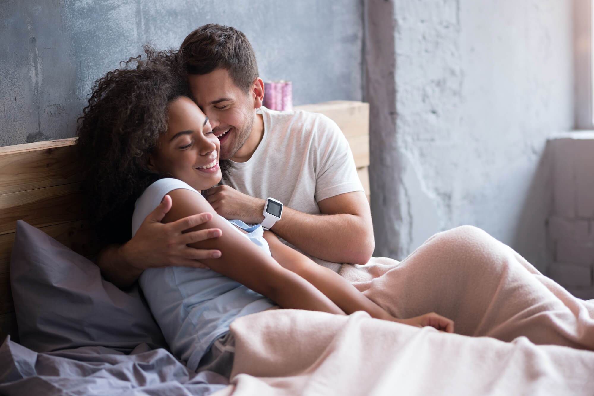 Couple cuddling in bed