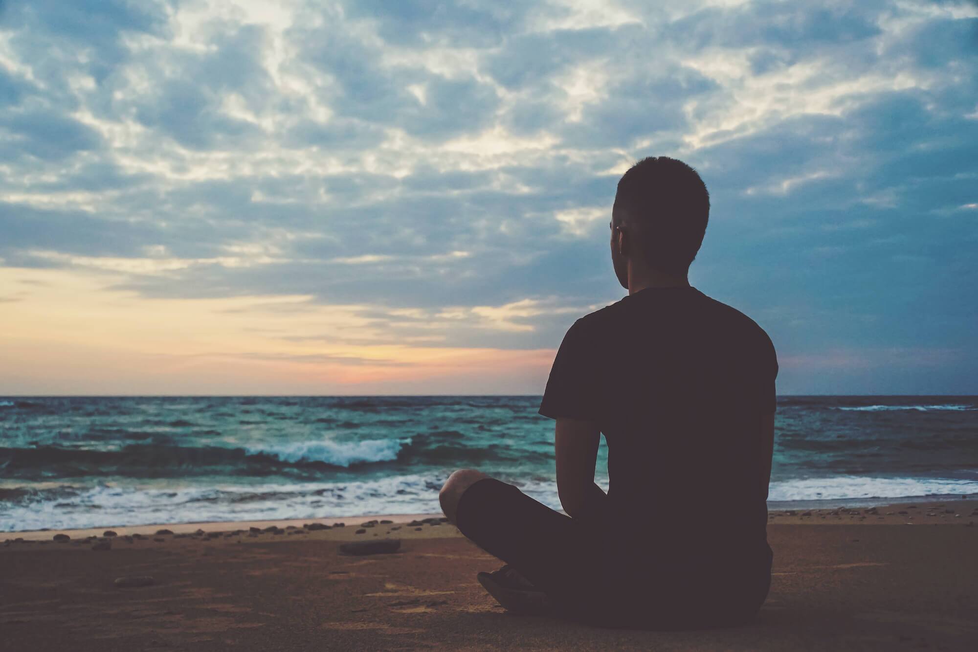 Man meditating on a beach