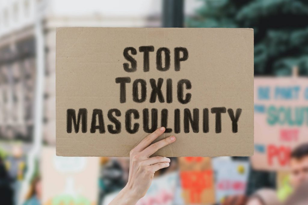 Man holding sign that says stop toxic masculinity