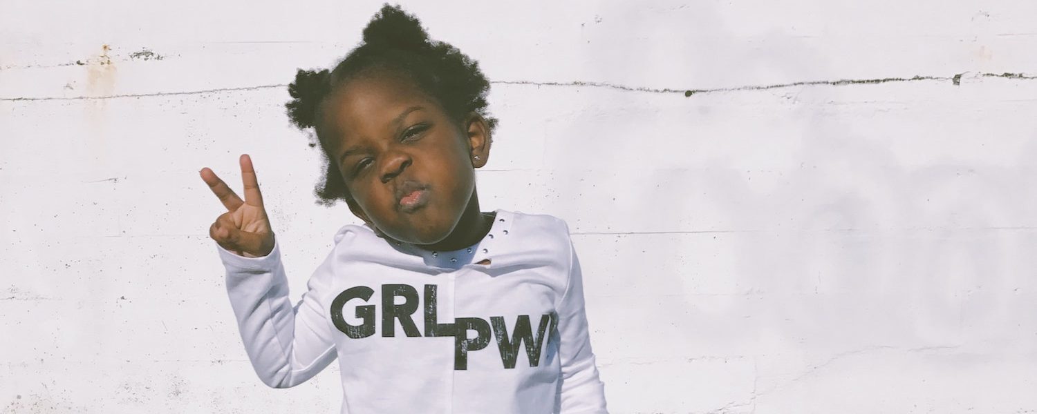 Girl Holding Peach Sign Wearing Girl Power Shirt