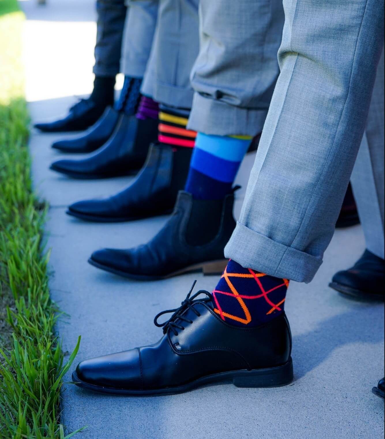 Row of men in suits with colourful socks