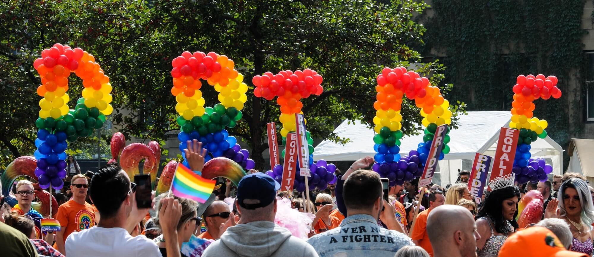 Pride parade with balloons that spell "Pride"