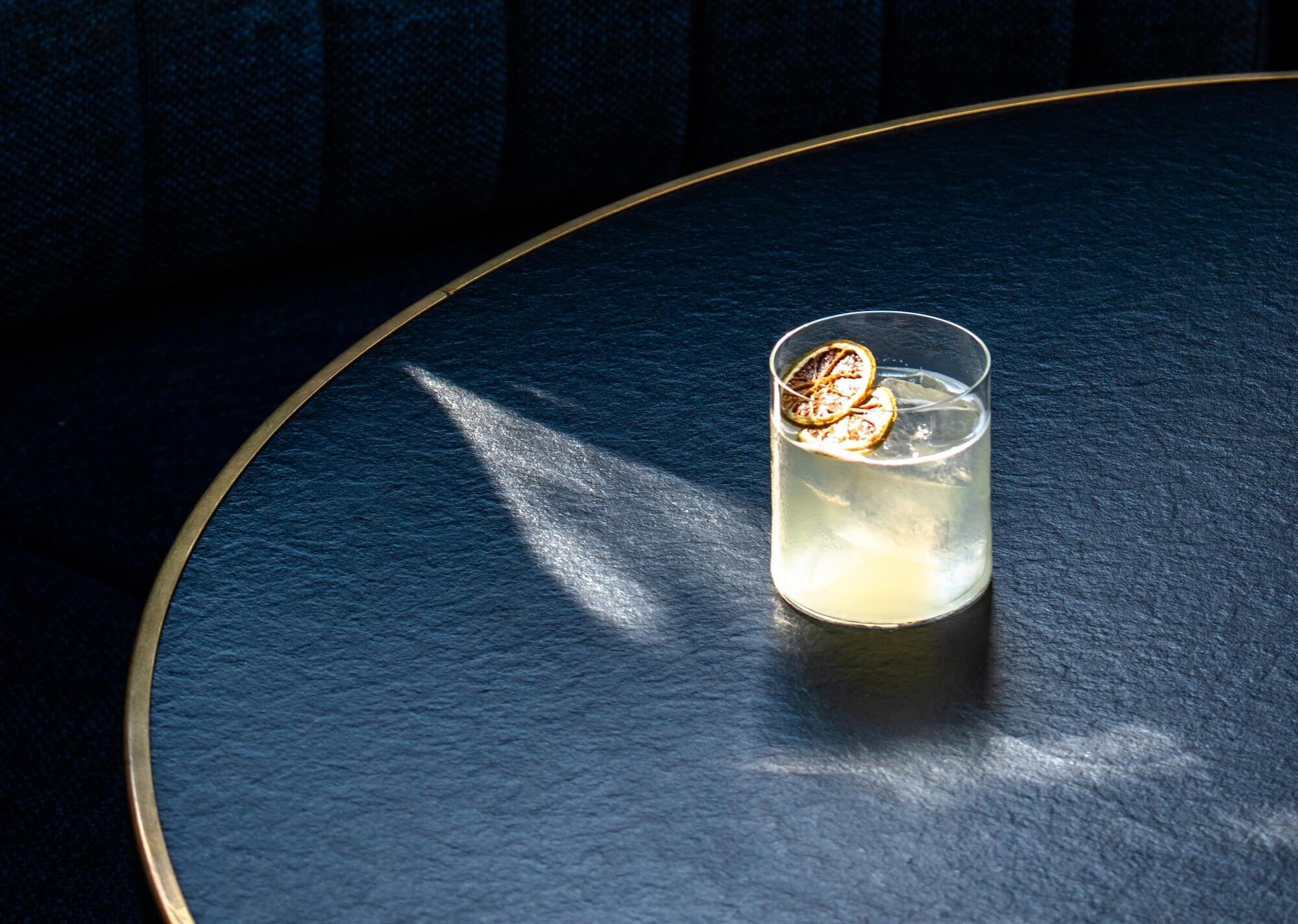 Cocktail with ice and candied lemon in tumbler