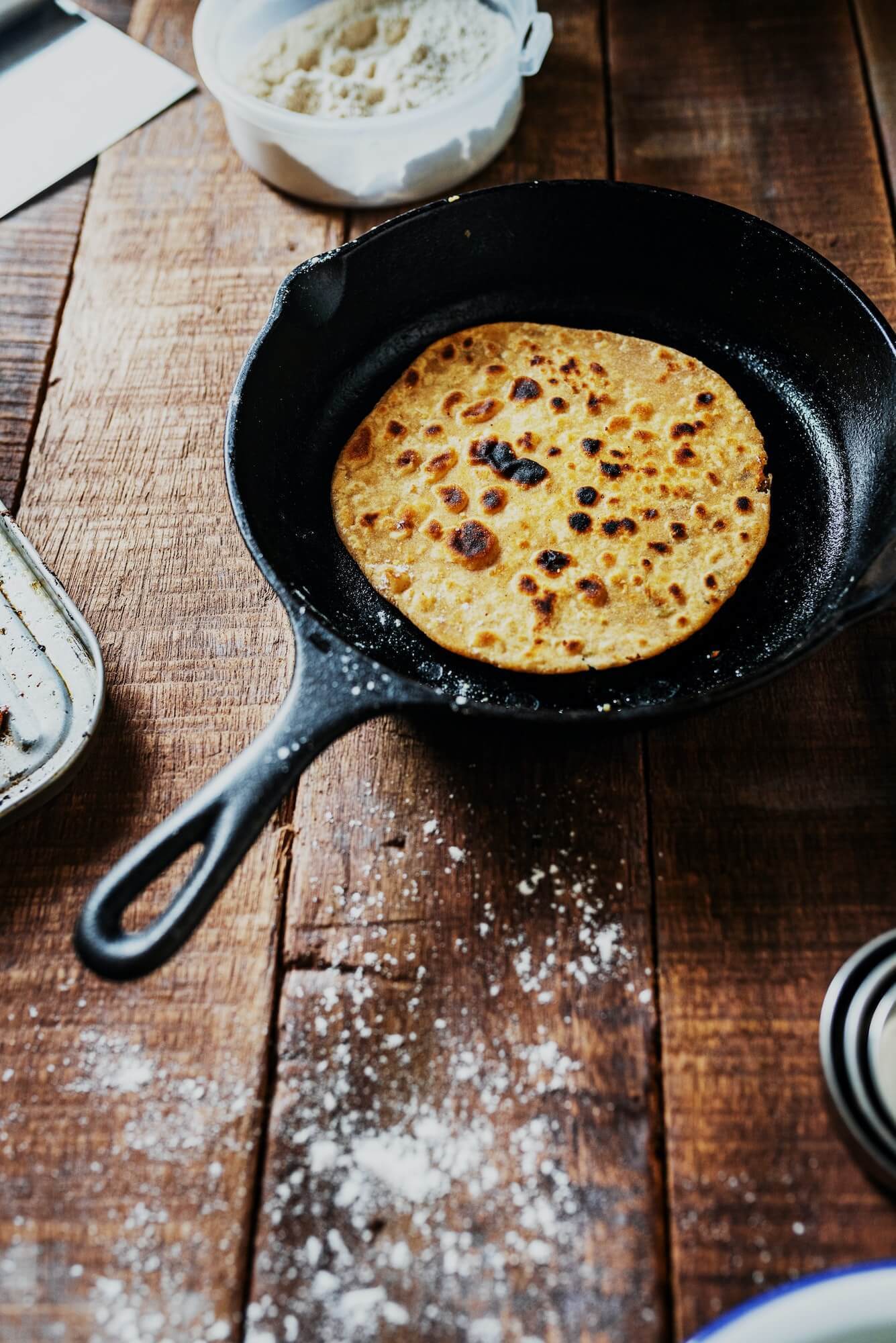 Crepe in cast iron skillet atop country-style wood table