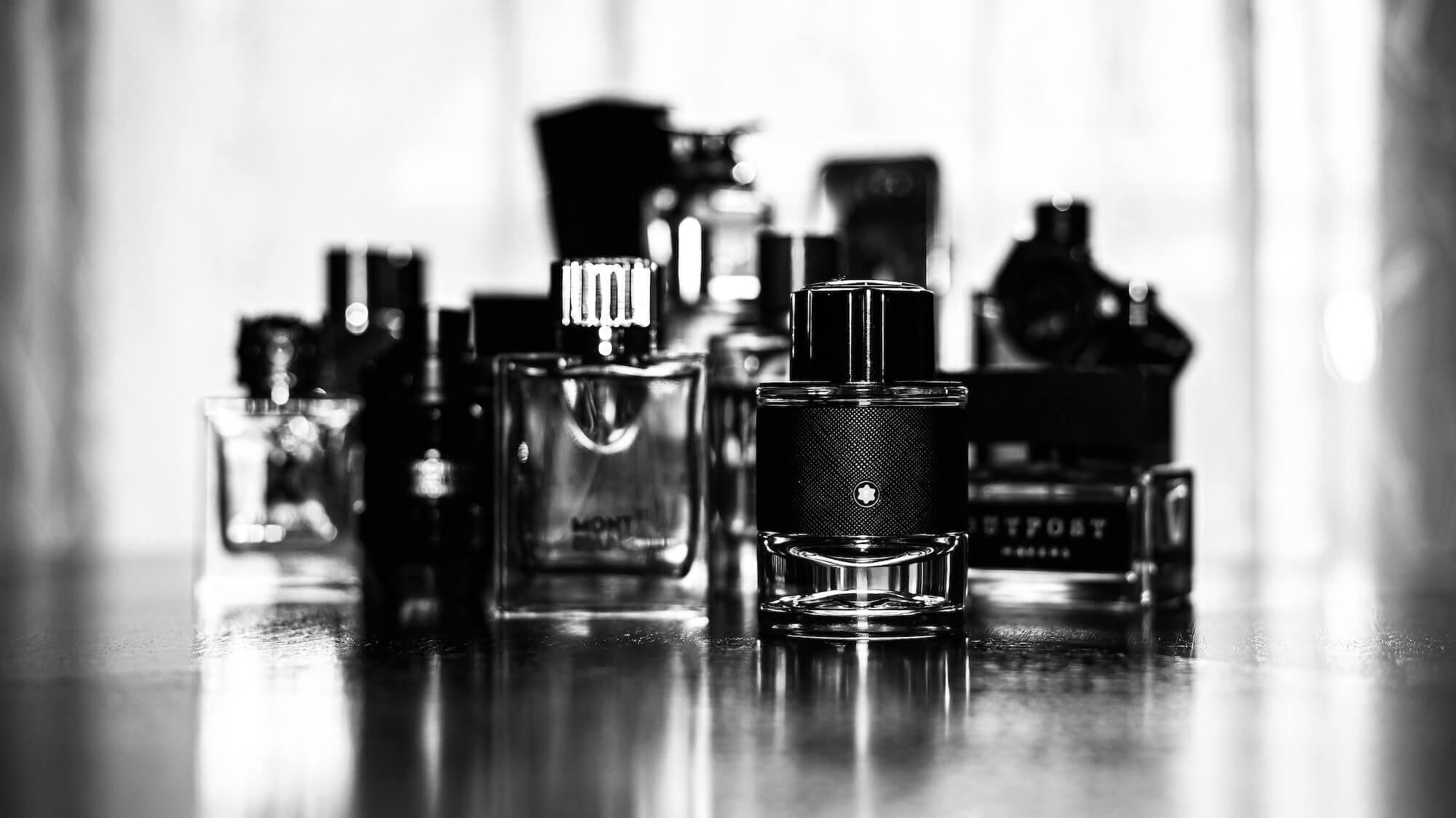 Black and white photo of a variety of men's cologne bottles