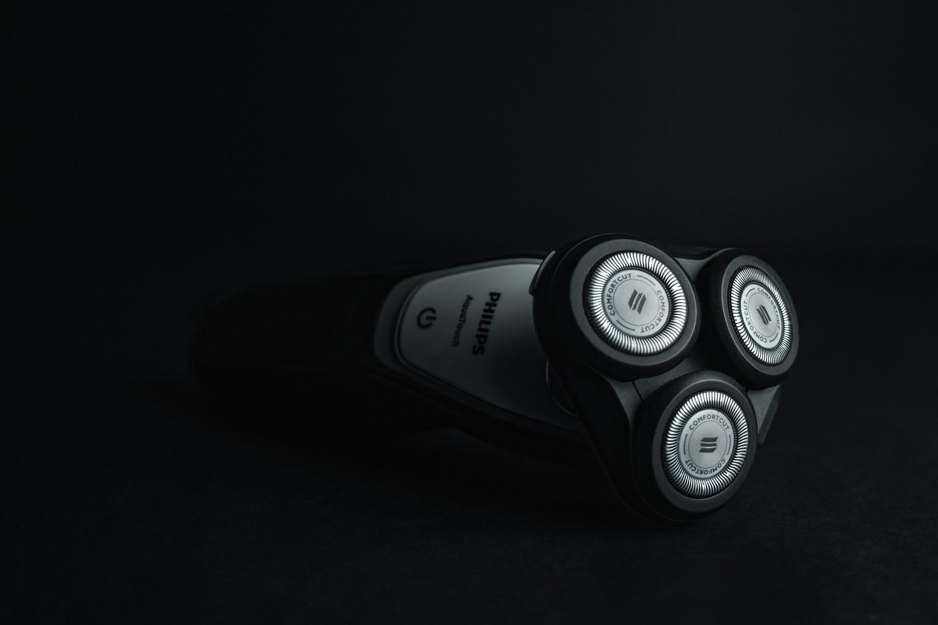 Close-up shot of Philips Aqua Touch electric razor against black background
