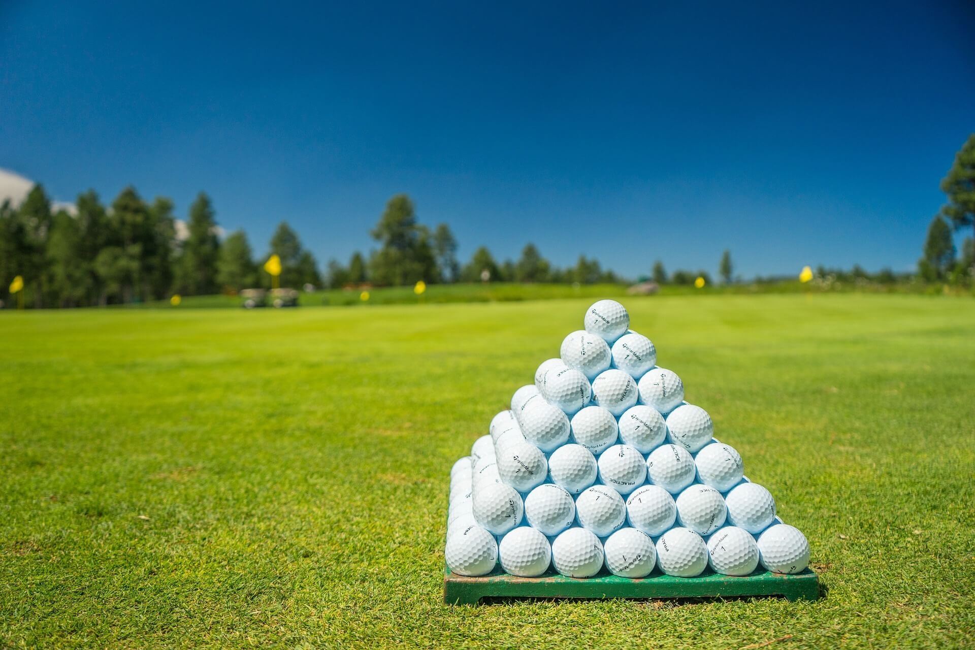 All-white golf ball pyramid on green course