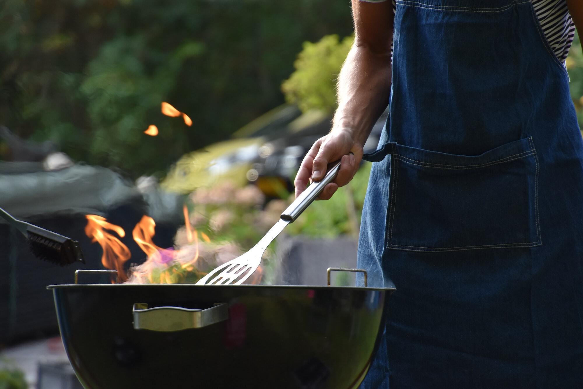 Man barbecuing on charcoal kettle grill