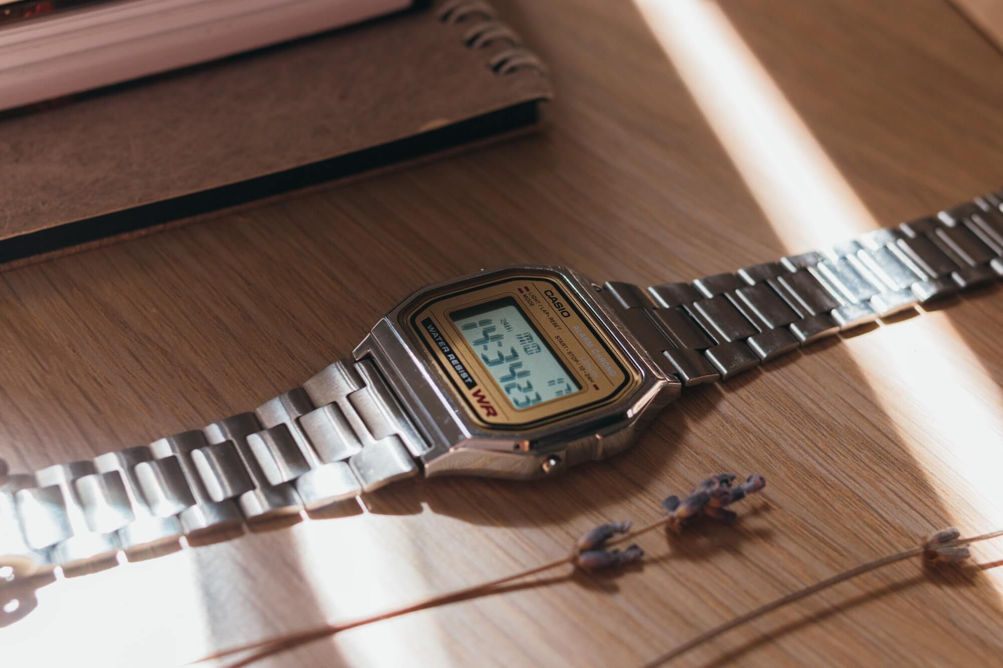 Casio digital watch displayed next to book