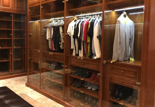 Men's luxury walk-in closet with hanging clothes